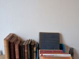 une pile de livres posée sur une table, à côté d'une autre pile de livres