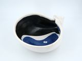 a white bowl with a black and blue whale inside of it