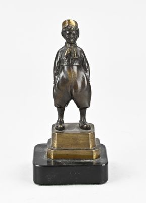 une image représentant une statue en bronze d'un garçon debout sur un socle