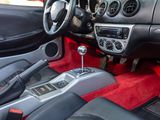 a dashboard of a car with red carpeting and a steering control