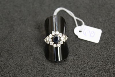 an image of a ring with a blue stone surrounded by white diamonds