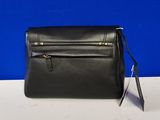 a black leather purse on a white table with a blue background