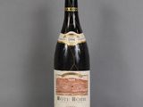 une vieille bouteille de vin posée sur une table en verre