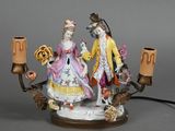 a figurine of a man and a woman holding a candelabra