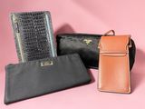 three black and brown wallets on a pink background