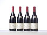three bottles of red wine are lined up on a table