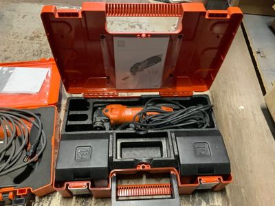 une boîte à outils orange contenant des outils, posée sur une table