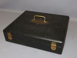 a black suitcase with a gold handle on a white table