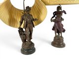 two bronze figurines of a man and a woman with a fan