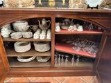 a wooden cabinet with a lot of dishes and glasses on it