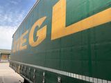 un semi-remorque vert et jaune garé sur un parking