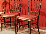 three chairs sitting next to each other against a red wall
