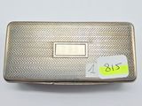 an old silver cigarette case with a sticker on it
