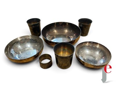 un ensemble de bols et de tasses en métal posés sur une surface blanche
