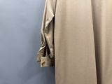 le dos d'un manteau suspendu à un cintre devant un mur bleu