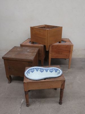 several pieces of furniture sitting on a cement floor next to a white wall