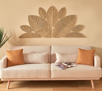 une photo d'un salon avec un canapé et une plante accrochée au mur