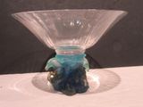 un vase en verre avec un socle bleu posé sur une table