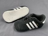 a pair of black and white shoes on a gray surface