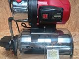 an image of a red and black electric water pump on a wooden surface