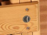 a close up of a wooden bench with a button on it