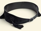a black belt with tassels on it on a white surface