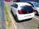 two cars parked in a parking lot next to a fence