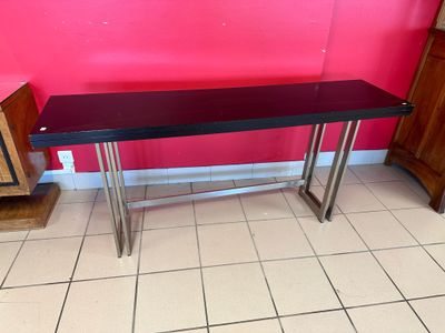 une table noire dans une pièce aux murs roses
