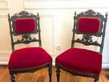 une paire de fauteuils rembourrés rouges posés sur le parquet d'une pièce