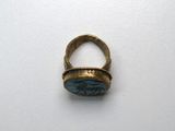 une image représentant une bague sertie d'une pierre, posée sur une surface blanche