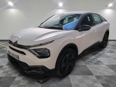 une voiture blanche garée dans une pièce au sol en damier