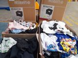 two boxes of clothes sitting on a carton in a warehouse