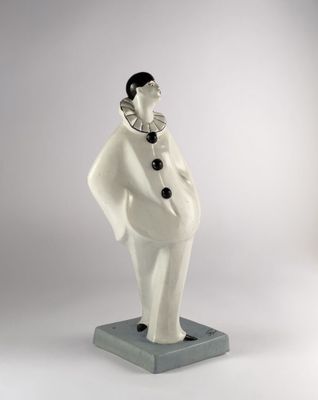 figurine of a woman wearing a white coat and a black hat
