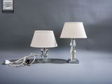 une paire de lampes de table en cristal avec des abat-jours blancs sur fond gris