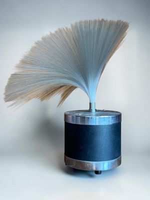 a blue vase with a white fan on top of it