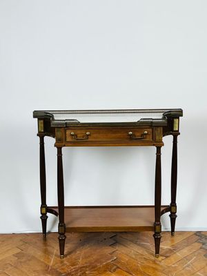une photo d'une table en bois avec un plateau en verre posée sur un parquet