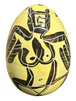 une image représentant un œuf peint en jaune et noir, sur lequel figure le portrait d'une femme