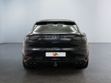 the rear end of a black car in a white room