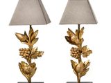 a pair of gold leaf lamps with shades on a white background