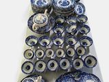 many blue and white plates and bowls on a table