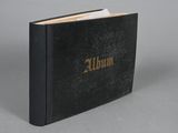a black book with gold lettering sitting on top of a gray surface