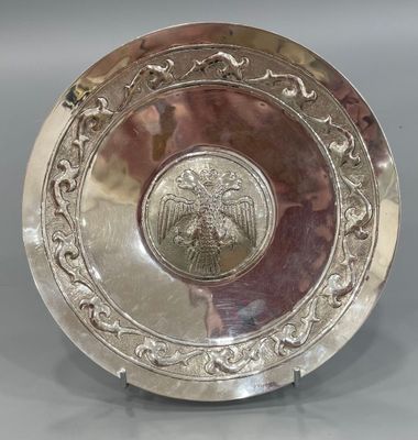 Plat en métal argenté sur un court pied orné au centre d'un …