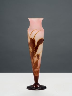 une photo d'un vase rose et marron posé sur une table blanche