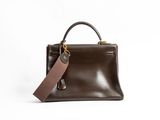a brown leather handbag with a brown tag on it