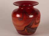 a red vase with a swirly design on it