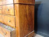 a wooden chest of drawers with a marble top