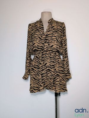 une robe à imprimé zébré marron et noir posée sur un pied de mannequin