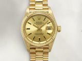 an image of a gold rolex watch sitting on a white surface