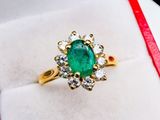 an image of a green emerald and diamond ring in a red box