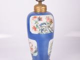 un vase bleu et blanc, muni d'un socle doré et d'une lampe